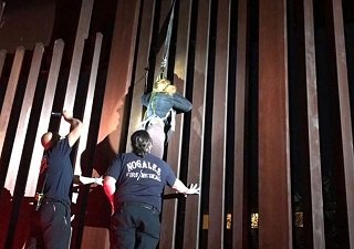 Dejan “polleros” a mujer colgada de muro fronterizo